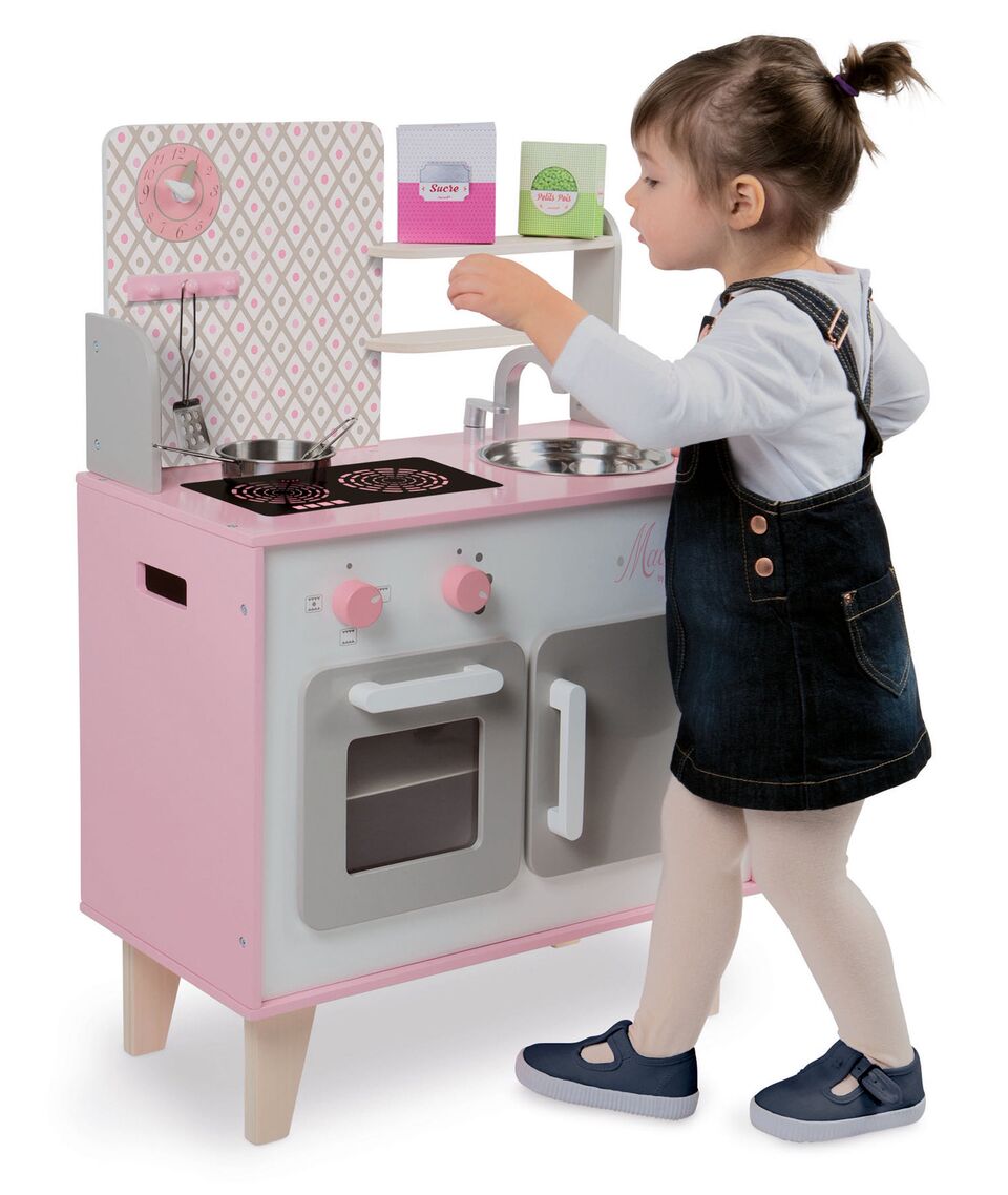 little girl playing with kitchen set